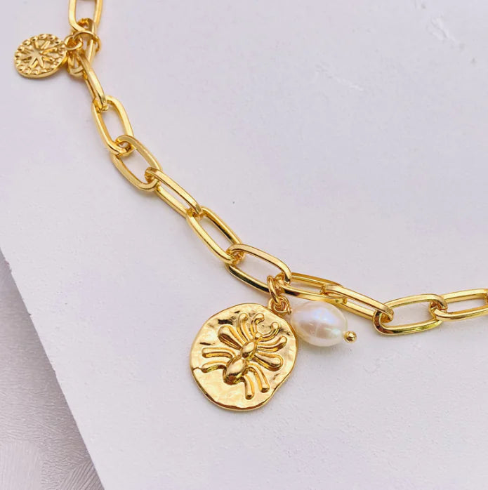 Naszyjnik z perłami i zawieszką – pająk, gwiazda i moneta na łańcuszku